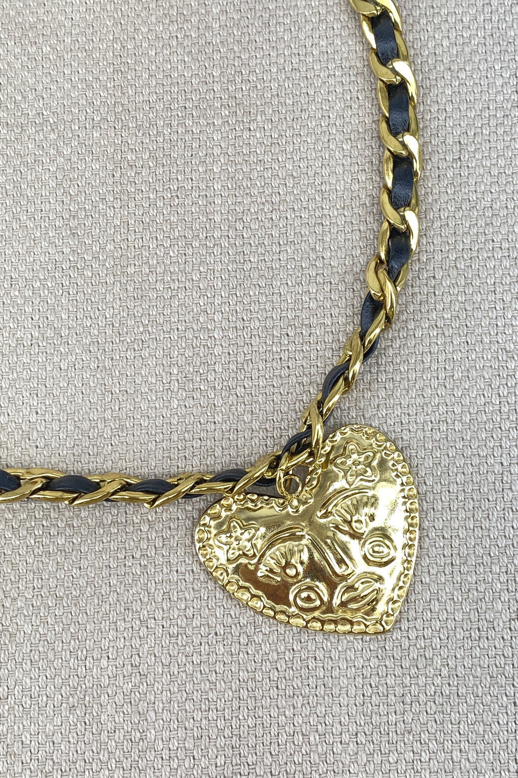 Gold heart-shaped pendant on a chain.